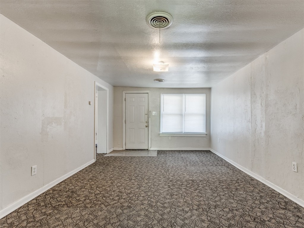 4900 S Blackwelder Avenue, Oklahoma City, OK 73119 spare room featuring carpet floors and a textured ceiling