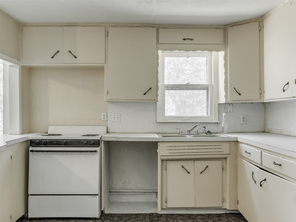 4900 S Blackwelder Avenue, Oklahoma City, OK 73119 kitchen featuring white electric stove, tasteful backsplash, cream cabinetry, and sink