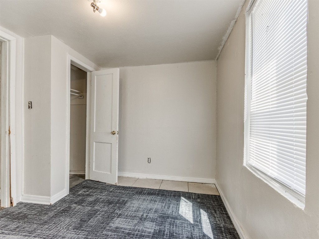 4900 S Blackwelder Avenue, Oklahoma City, OK 73119 unfurnished bedroom featuring dark tile floors and a closet