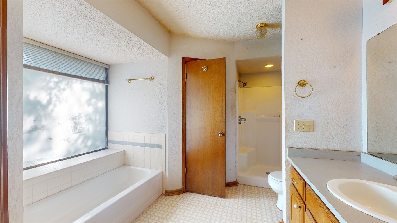 3100 SW 93rd Street, Oklahoma City, OK 73159 bathroom featuring tile flooring, vanity, toilet, and a textured ceiling