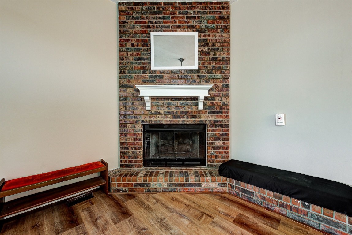 1416 NW Craig Drive, Piedmont, OK 73078 living room with brick wall, hardwood / wood-style flooring, and a fireplace