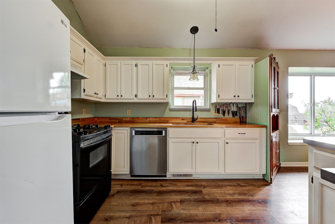 1416 NW Craig Drive, Piedmont, OK 73078 kitchen featuring dishwasher, dark wood-type flooring, white refrigerator, decorative light fixtures, and black gas stove