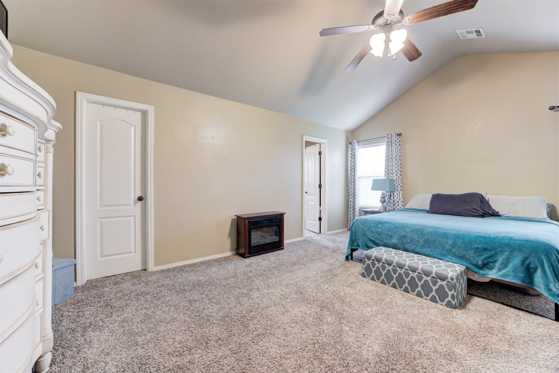 4604 SW 122nd Street, Oklahoma City, OK 73173 bedroom featuring ceiling fan, vaulted ceiling, and light carpet