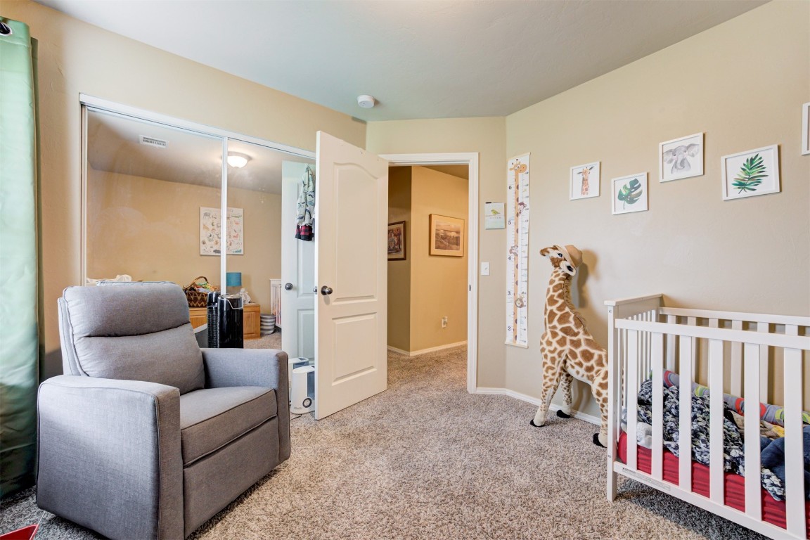 4604 SW 122nd Street, Oklahoma City, OK 73173 bedroom with light carpet and a nursery area