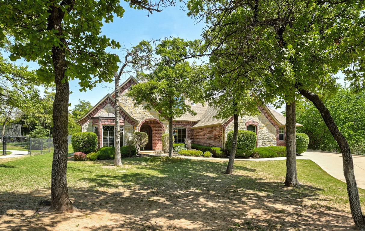 2123 Estancia Circle, Edmond, OK 73034 back of property featuring a patio, a fire pit, and a lawn