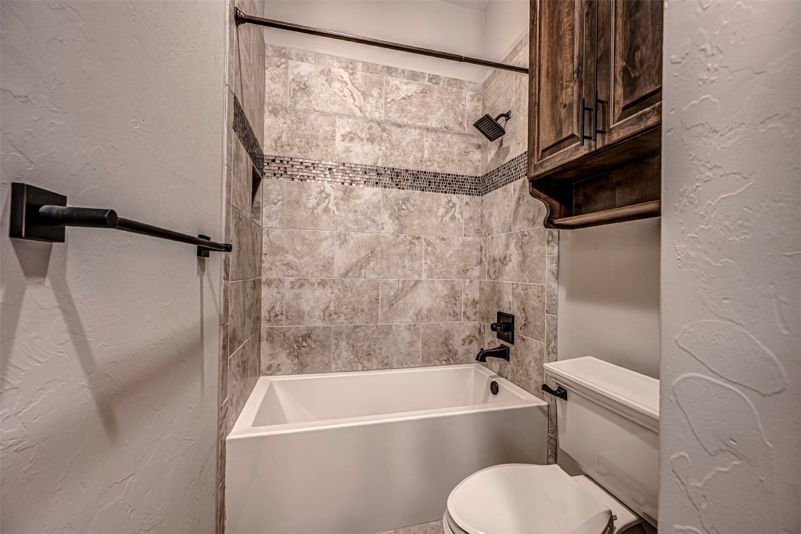 8348 NW 129th Court, Oklahoma City, OK 73142 bathroom with tiled shower / bath and toilet