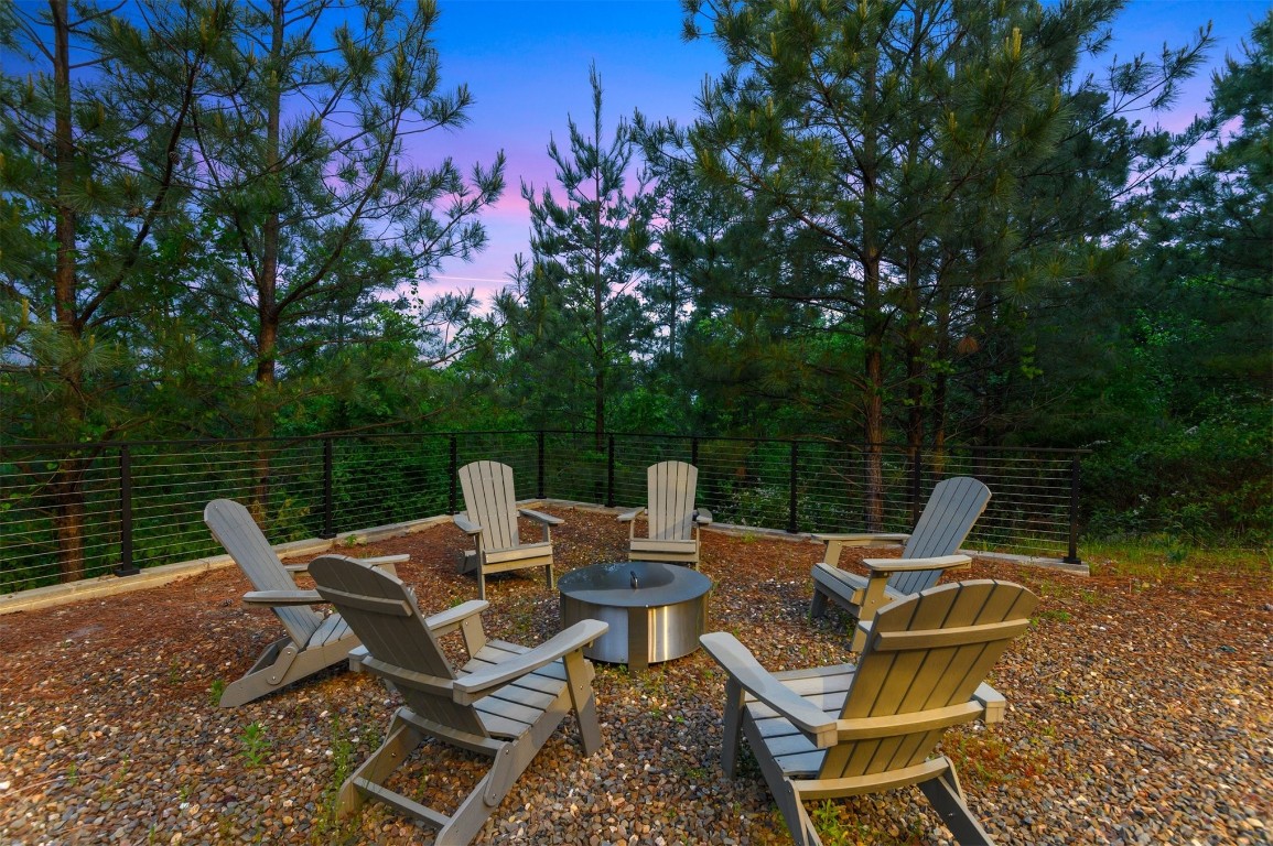 157 Woodland Bluff Trail, Broken Bow, OK 74728 patio terrace at dusk featuring a fire pit