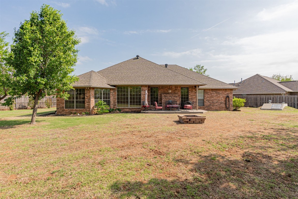 314 NW Cypress Street, Piedmont, OK 73078 back of property featuring an outdoor fire pit, a lawn, and a patio area