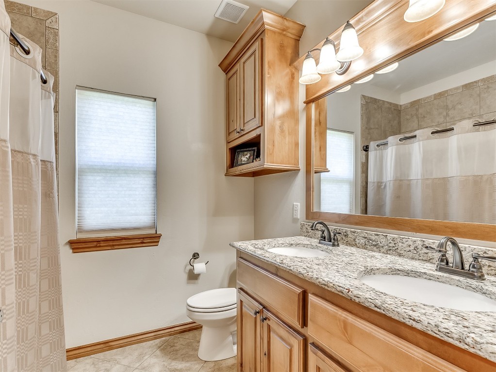 519 Harold Drive, #NE, Piedmont, OK 73078 bathroom featuring a healthy amount of sunlight, toilet, tile floors, and dual vanity