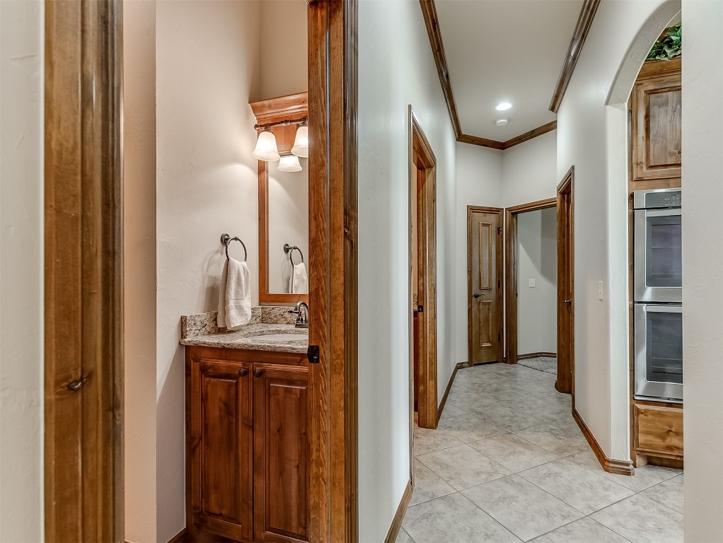519 Harold Drive, #NE, Piedmont, OK 73078 corridor featuring ornamental molding, sink, and light tile flooring