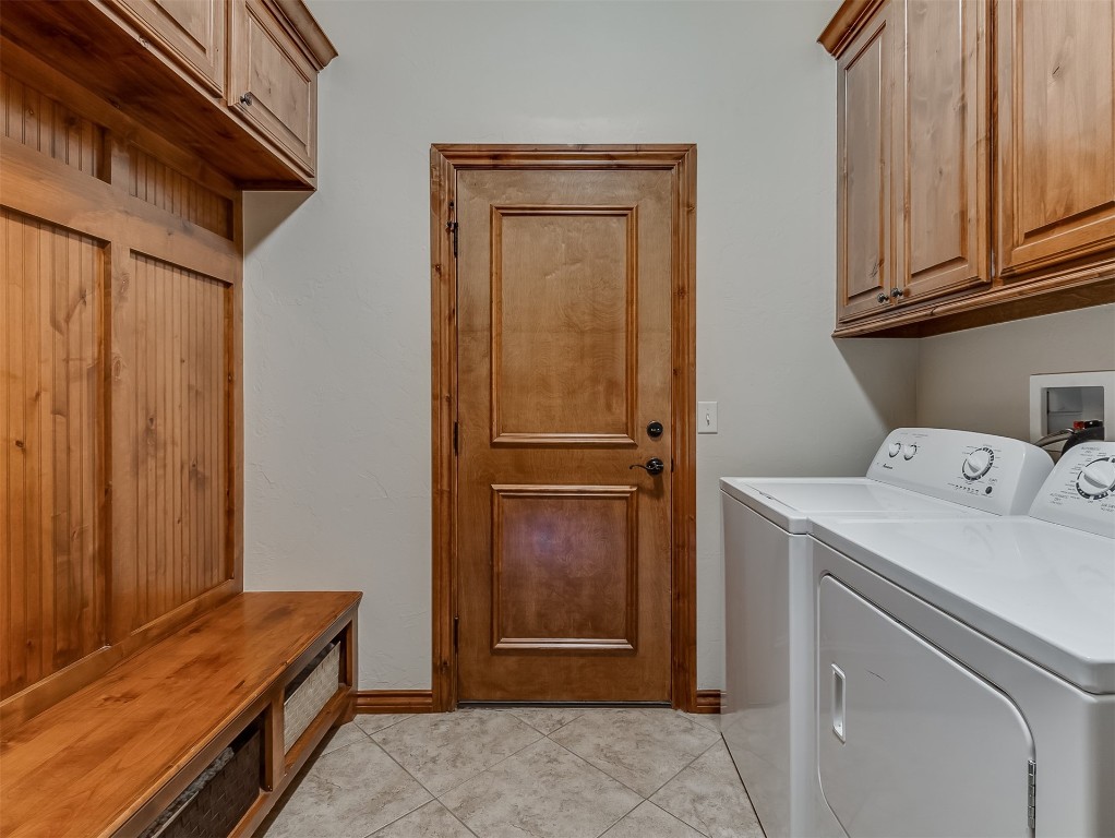 519 Harold Drive, #NE, Piedmont, OK 73078 laundry room with light tile flooring, washer and dryer, cabinets, and hookup for a washing machine