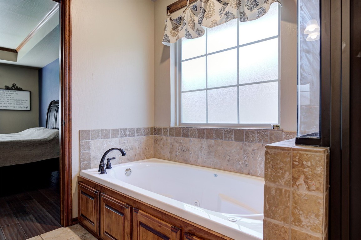 17208 Prado Drive, Oklahoma City, OK 73170 bathroom featuring ornamental molding and a bathing tub