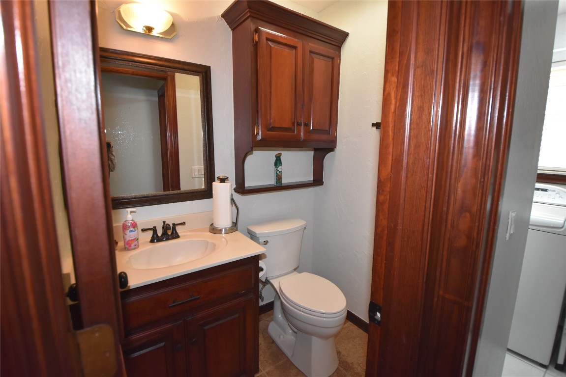 4200 Ainsley Court, Edmond, OK 73034 bathroom featuring vanity, washer / clothes dryer, toilet, and tile flooring