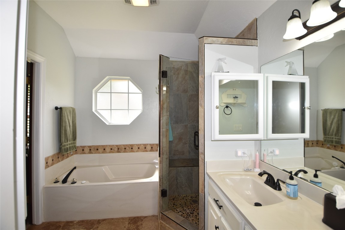 4200 Ainsley Court, Edmond, OK 73034 bathroom featuring tile flooring, lofted ceiling, oversized vanity, and shower with separate bathtub