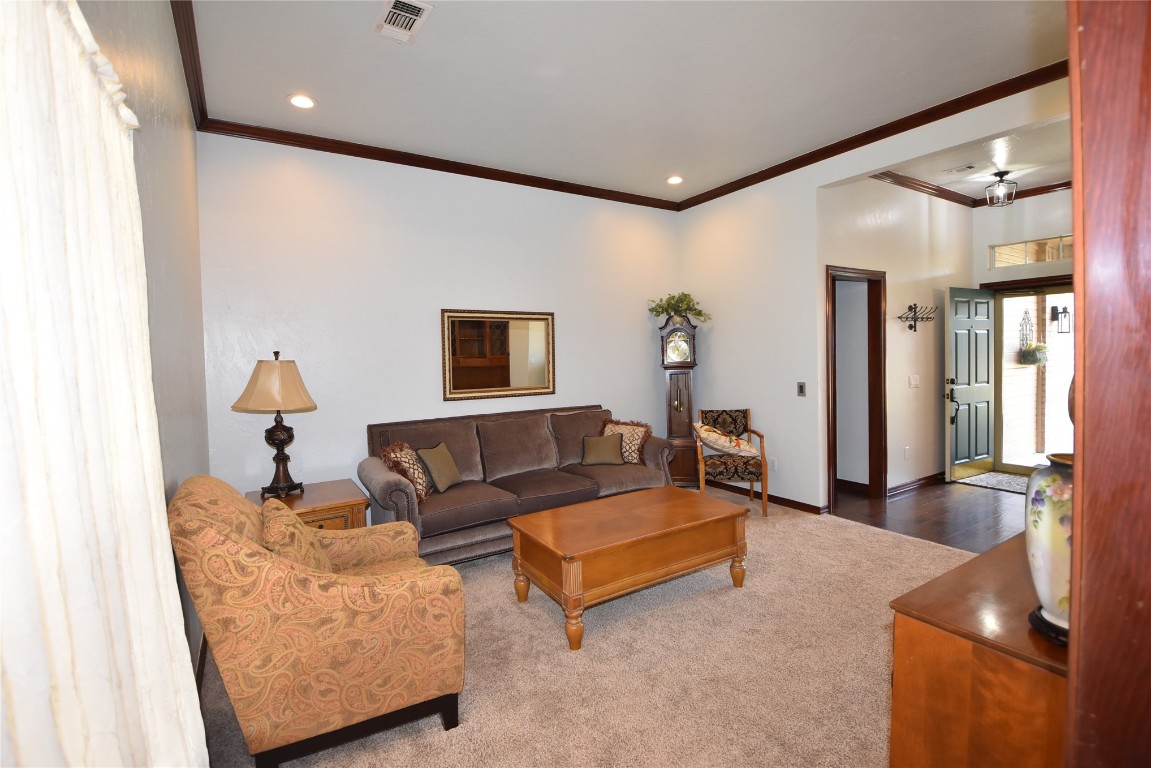 4200 Ainsley Court, Edmond, OK 73034 carpeted living room with ornamental molding