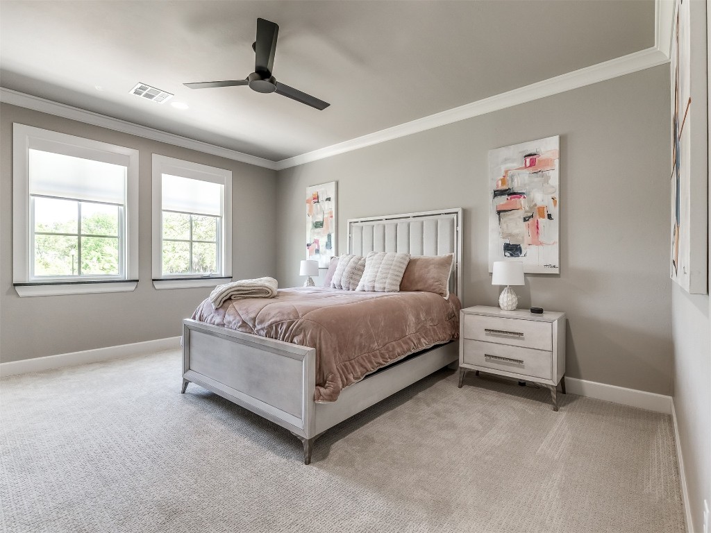 4324 Corridor Drive, Edmond, OK 73034 bedroom featuring light carpet, ceiling fan, and crown molding