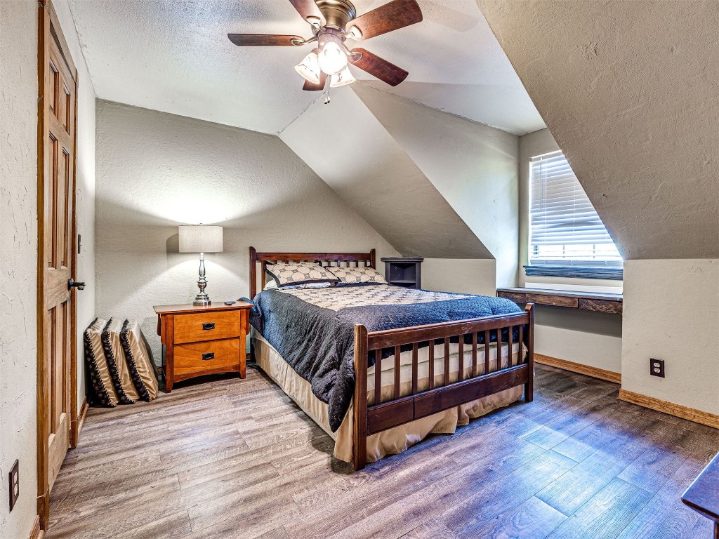 1580 NW 220th Street, Edmond, OK 73025 bedroom featuring lofted ceiling, ceiling fan, hardwood / wood-style flooring, and a textured ceiling