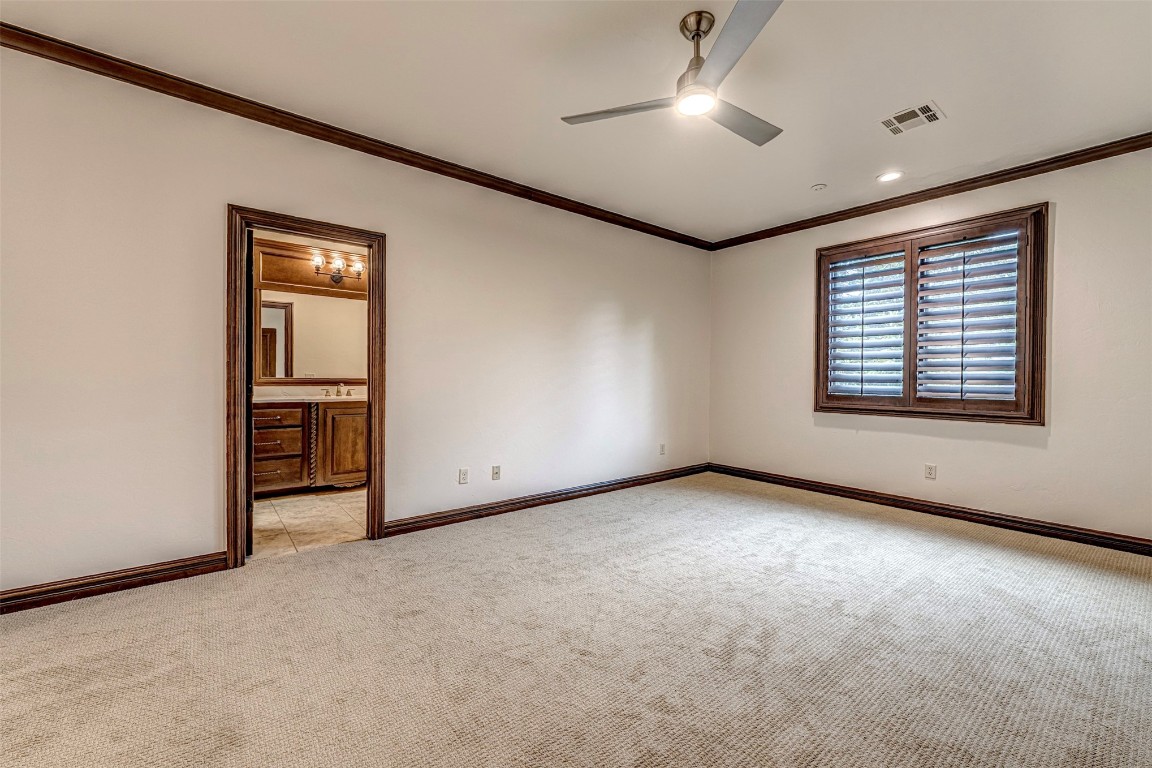 6516 NW Grand Boulevard, Nichols Hills, OK 73116 empty room with ornamental molding, light colored carpet, and ceiling fan