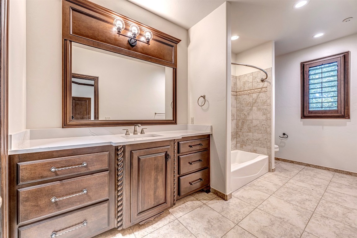 6516 NW Grand Boulevard, Nichols Hills, OK 73116 full bathroom featuring tiled shower / bath, toilet, tile flooring, and vanity