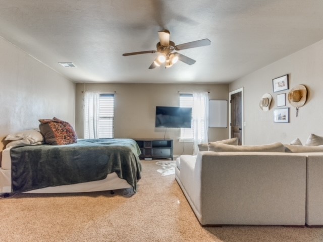 18309 Haslemere Lane, Edmond, OK 73012 bedroom with light colored carpet and ceiling fan