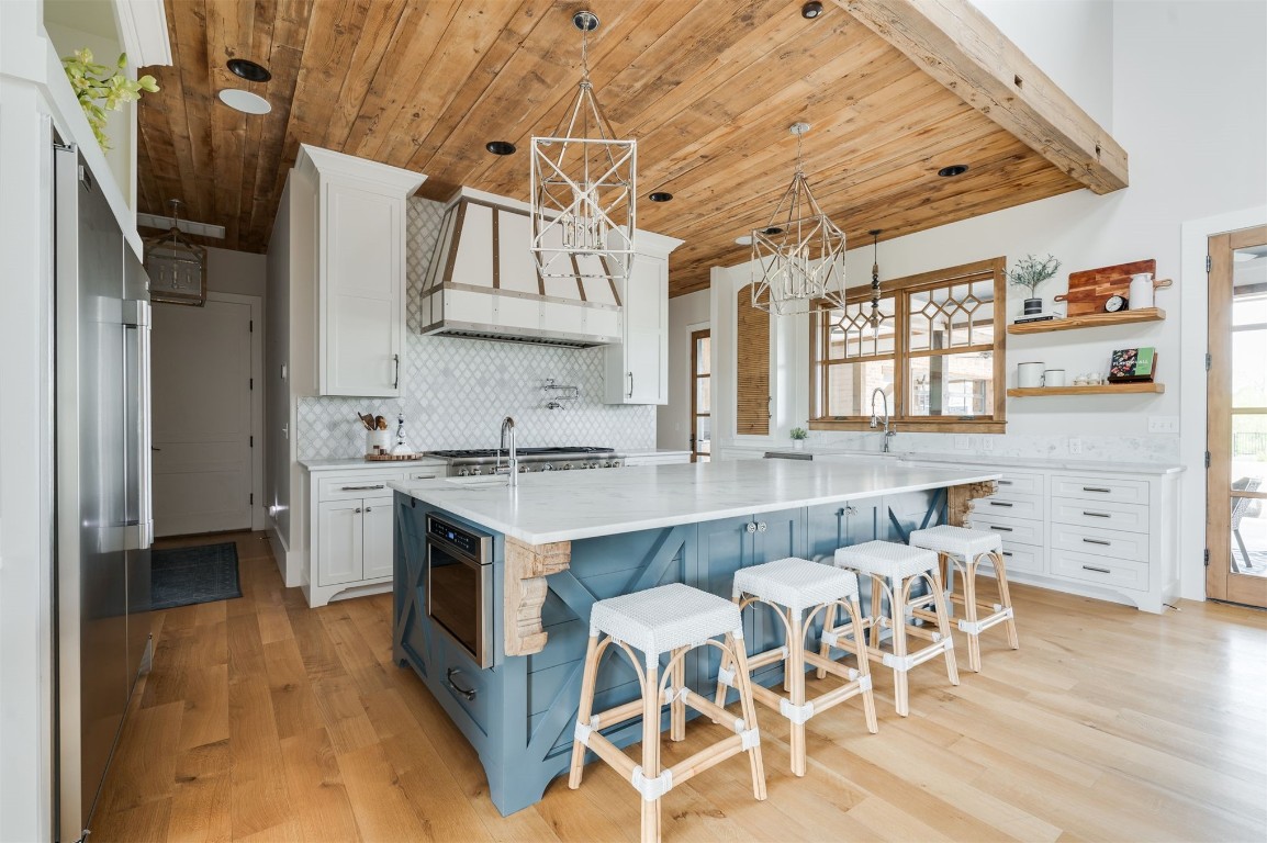 9301 Farmhouse Lane, Arcadia, OK 73007 kitchen with a healthy amount of sunlight, light hardwood / wood-style flooring, tasteful backsplash, and white cabinetry