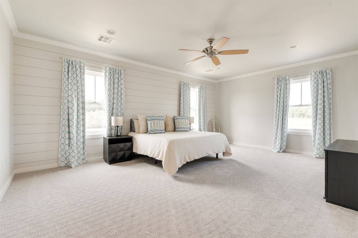 9301 Farmhouse Lane, Arcadia, OK 73007 carpeted bedroom with ceiling fan and ornamental molding