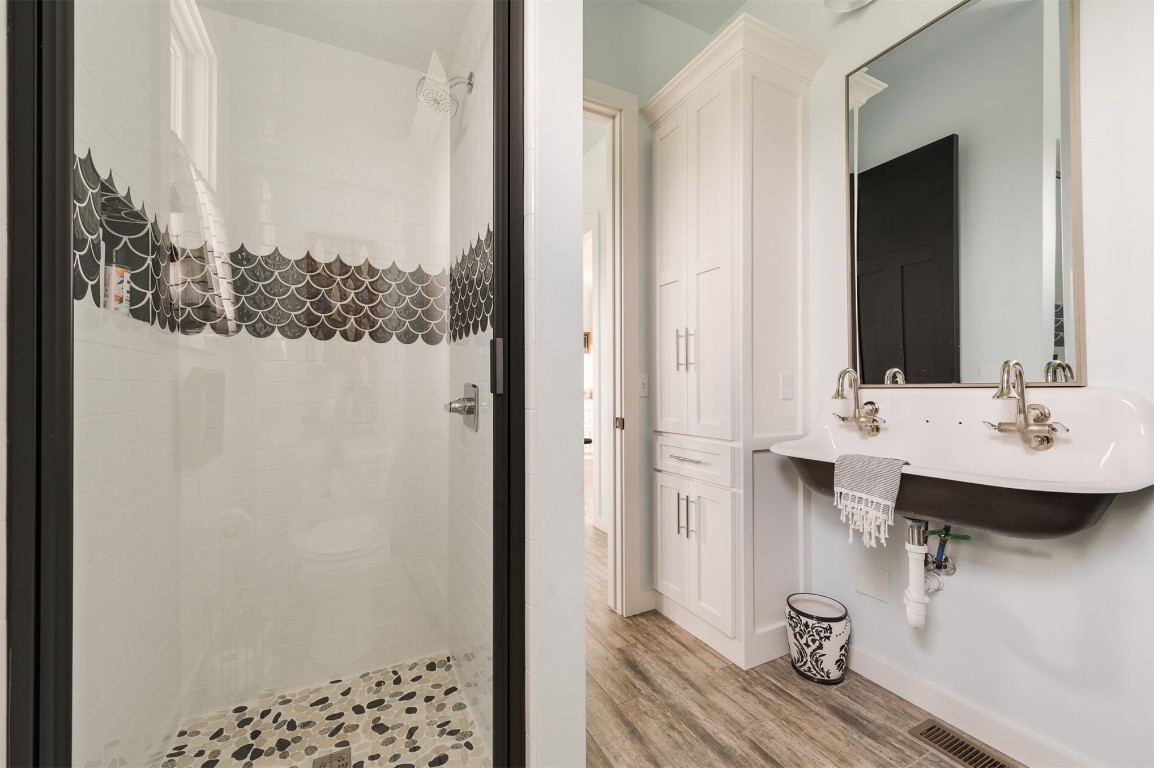 9301 Farmhouse Lane, Arcadia, OK 73007 bathroom with hardwood / wood-style flooring and a tile shower