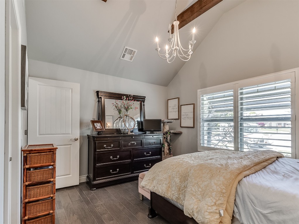 8000 NW 67th Place, Warr Acres, OK 73132 bedroom featuring high vaulted ceiling, dark hardwood / wood-style flooring, beam ceiling, and an inviting chandelier