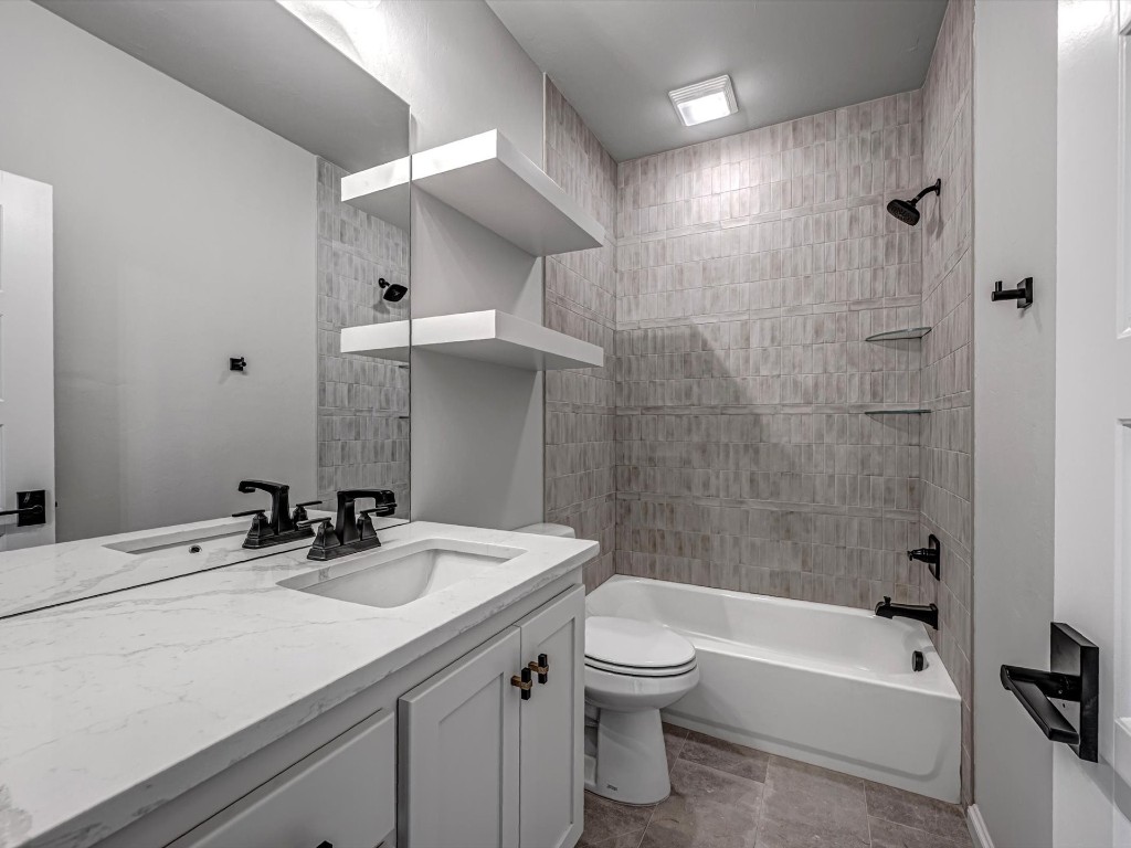 4217 Grand Timber Drive, Edmond, OK 73034 full bathroom featuring tiled shower / bath, toilet, tile flooring, and large vanity