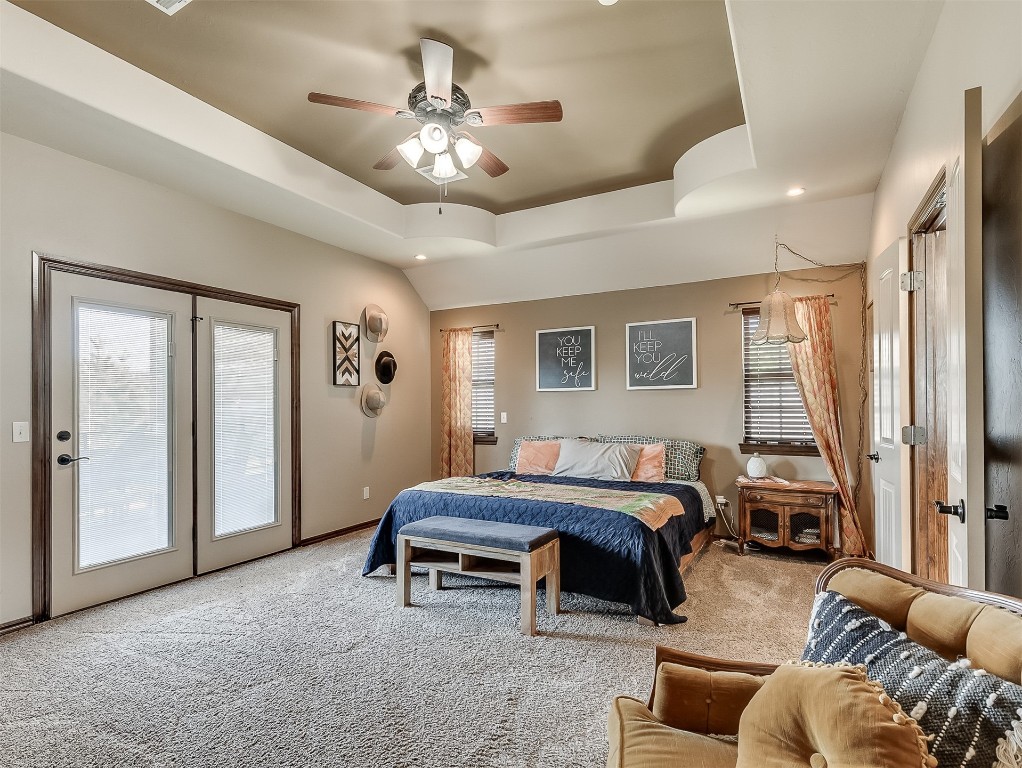 705 Evening Drive, Yukon, OK 73099 carpeted bedroom featuring a raised ceiling, ceiling fan, and access to exterior