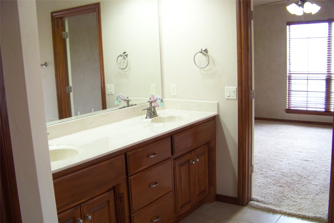 8317 NW 62nd Street, Oklahoma City, OK 73132 bathroom featuring double vanity and tile floors