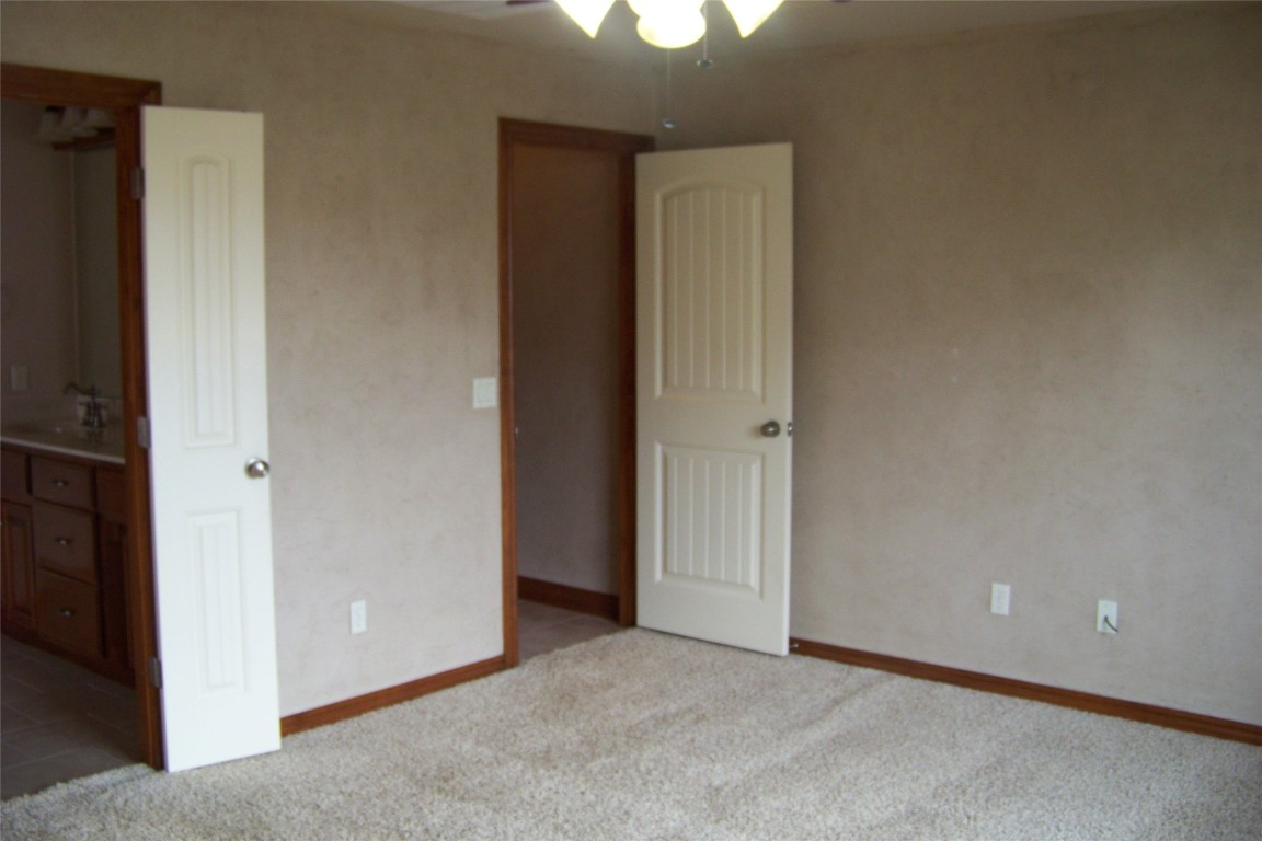 8317 NW 62nd Street, Oklahoma City, OK 73132 unfurnished bedroom with carpet floors, ceiling fan, and sink