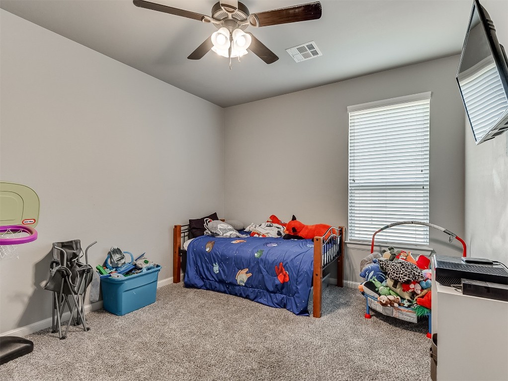 11216 SW 42nd Court, Mustang, OK 73064 bedroom with ceiling fan and carpet floors