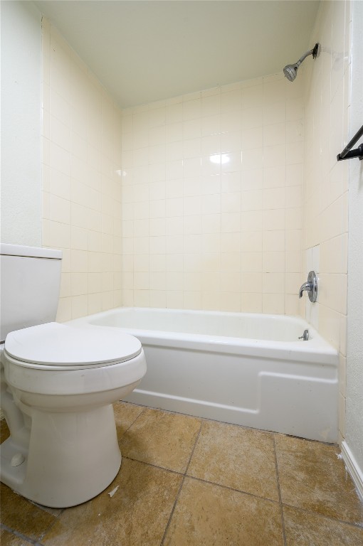 1719 E Lindsey Street, #1, Norman, OK 73071 bathroom with tiled shower / bath combo, tile floors, and toilet