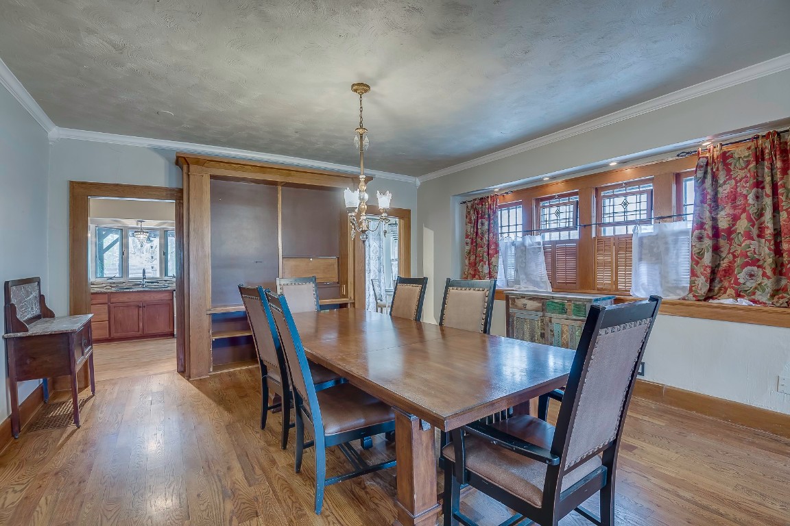 Address Hidden dining room featuring crown molding, light wood-type flooring, and a chandelier
