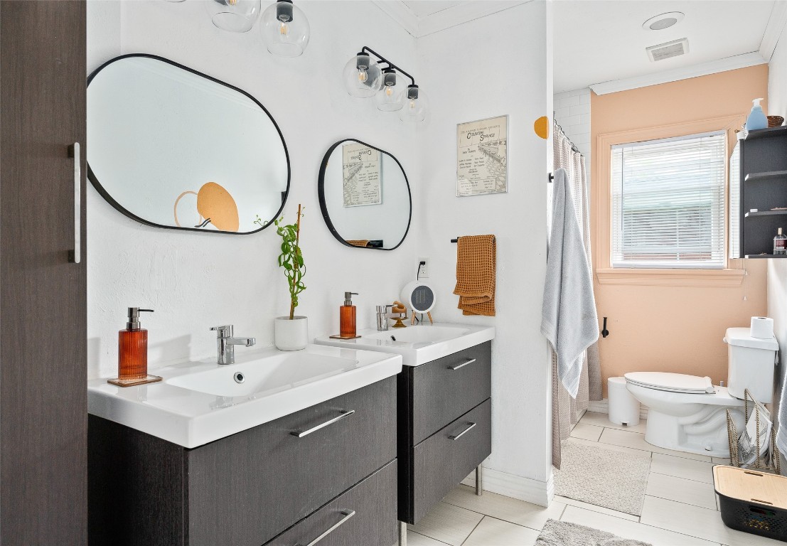 3028 NW 13th Street, Oklahoma City, OK 73107 bathroom featuring dual vanity, crown molding, toilet, and tile flooring