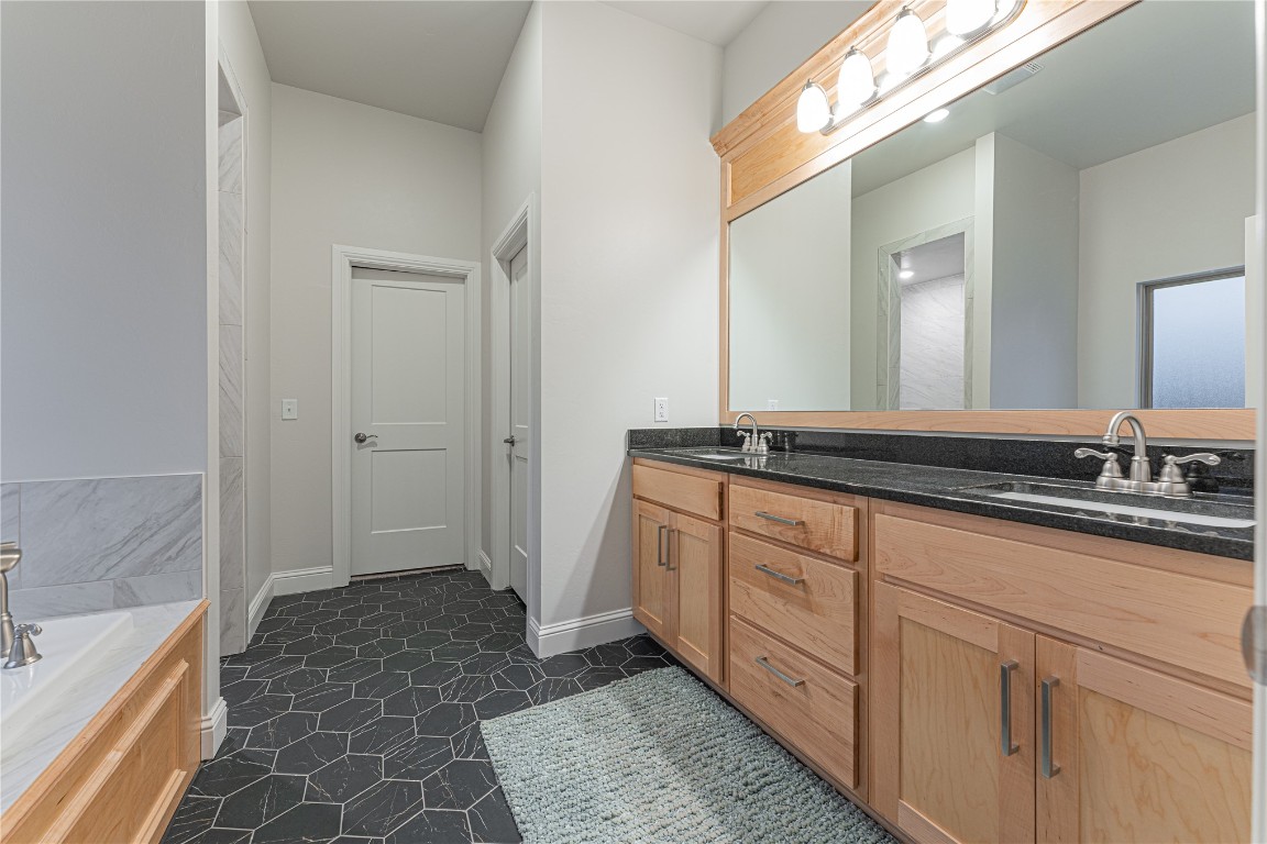 9016 NE 141st Street, Jones, OK 73049 bathroom with oversized vanity, dual sinks, a bath, and tile flooring