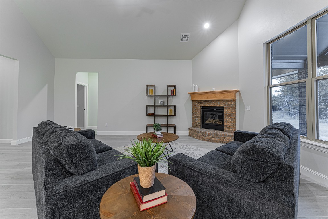 9016 NE 141st Street, Jones, OK 73049 living room featuring lofted ceiling, light wood-type flooring, and a fireplace