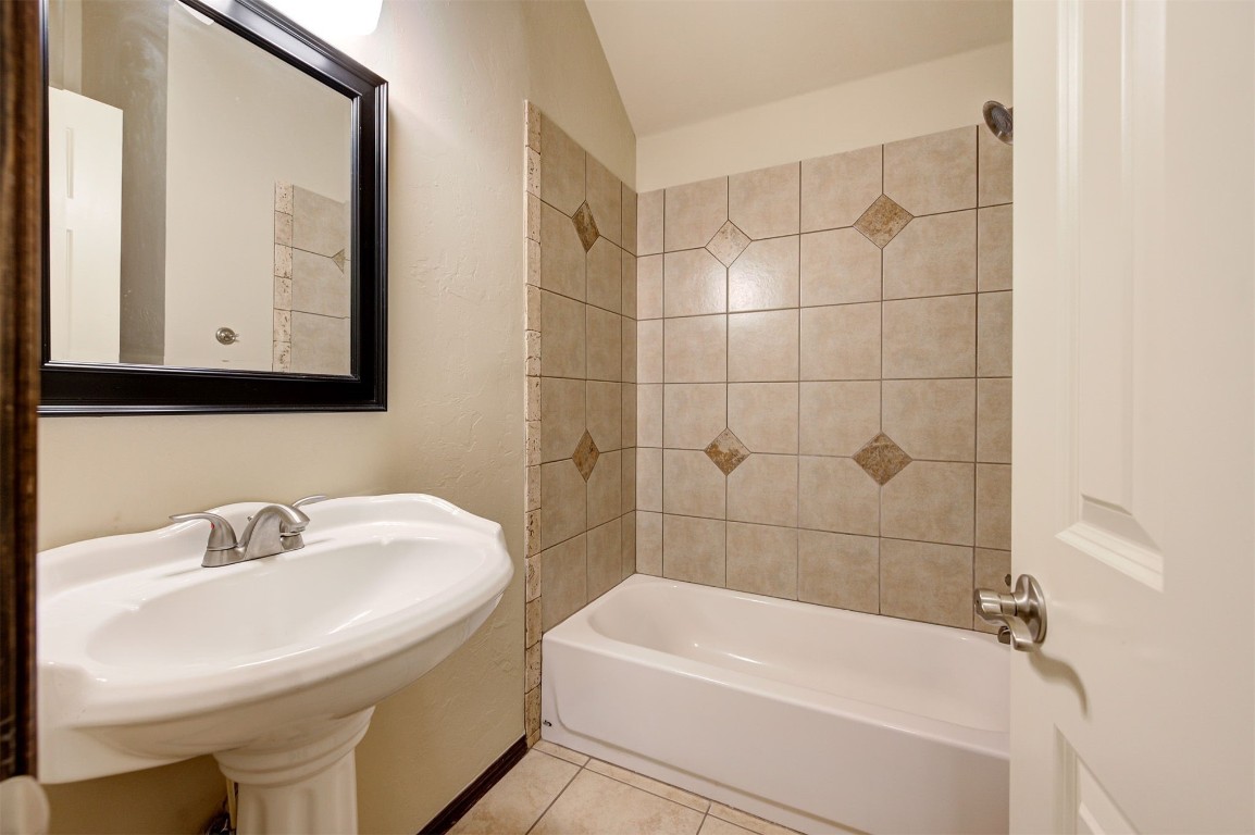 11748 SW 21st Street, Yukon, OK 73099 bathroom with tiled shower / bath combo, sink, and tile floors
