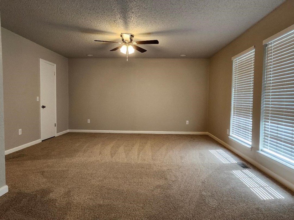 9800 S Country Club Drive, Oklahoma City, OK 73159 carpeted spare room with ceiling fan and a textured ceiling