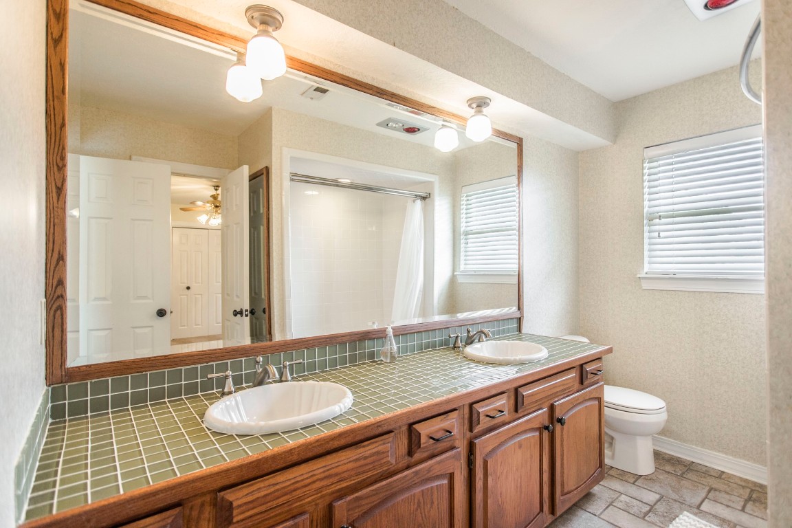 6625 NW 113th Street, Oklahoma City, OK 73162 bathroom featuring a healthy amount of sunlight, toilet, dual vanity, and tile flooring