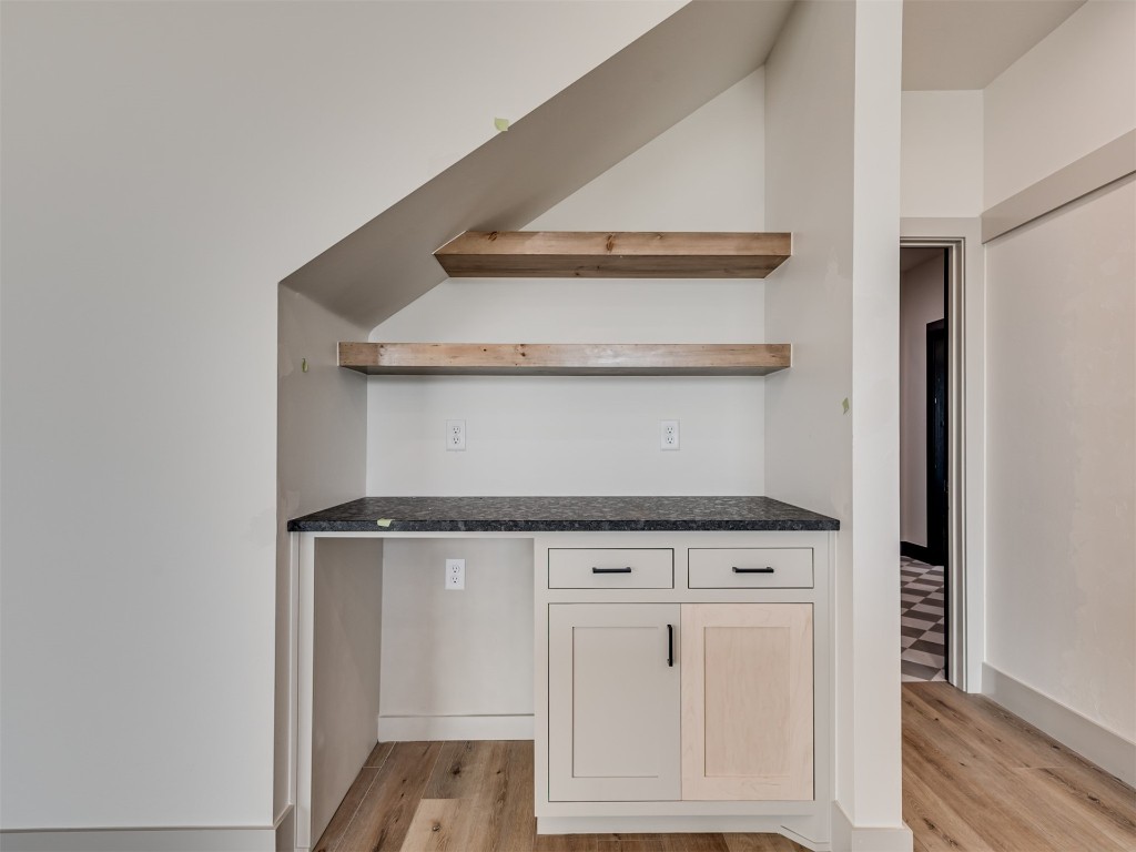 118 NE Primrose Point Avenue, Piedmont, OK 73128 kitchen featuring dark stone countertops and light hardwood / wood-style floors