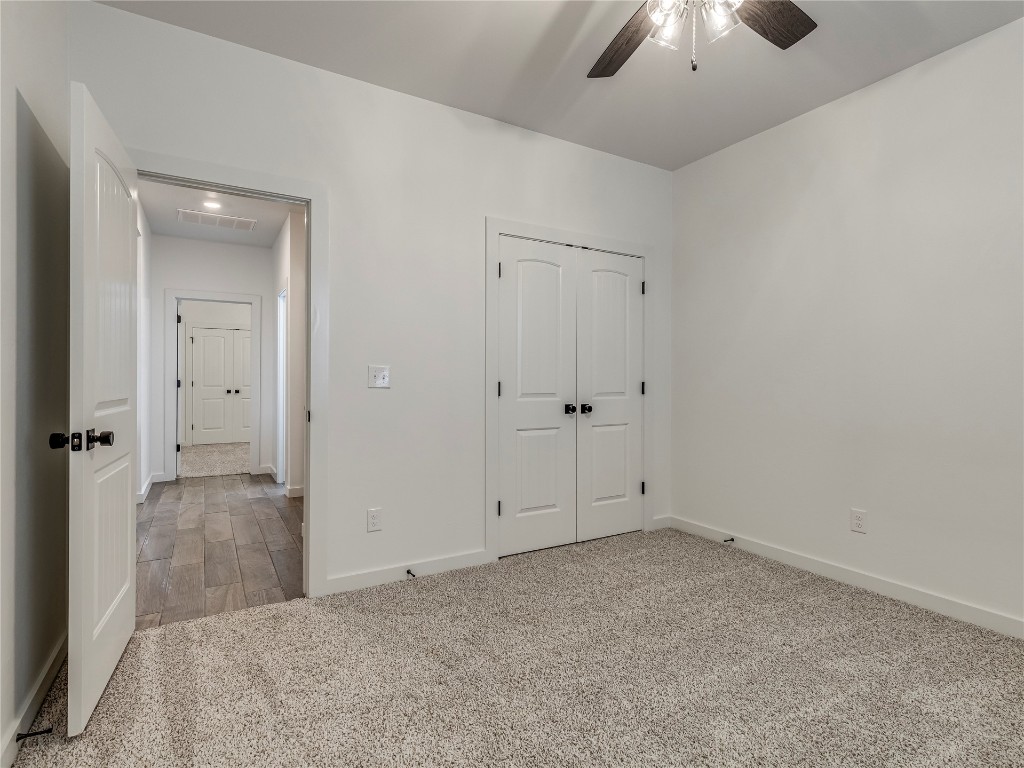 143 Primrose Point Avenue, Piedmont, OK 73078 unfurnished bedroom with a closet, light carpet, and ceiling fan