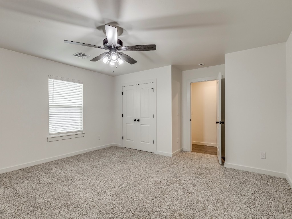 143 Primrose Point Avenue, Piedmont, OK 73078 unfurnished bedroom with light colored carpet, ceiling fan, and a closet