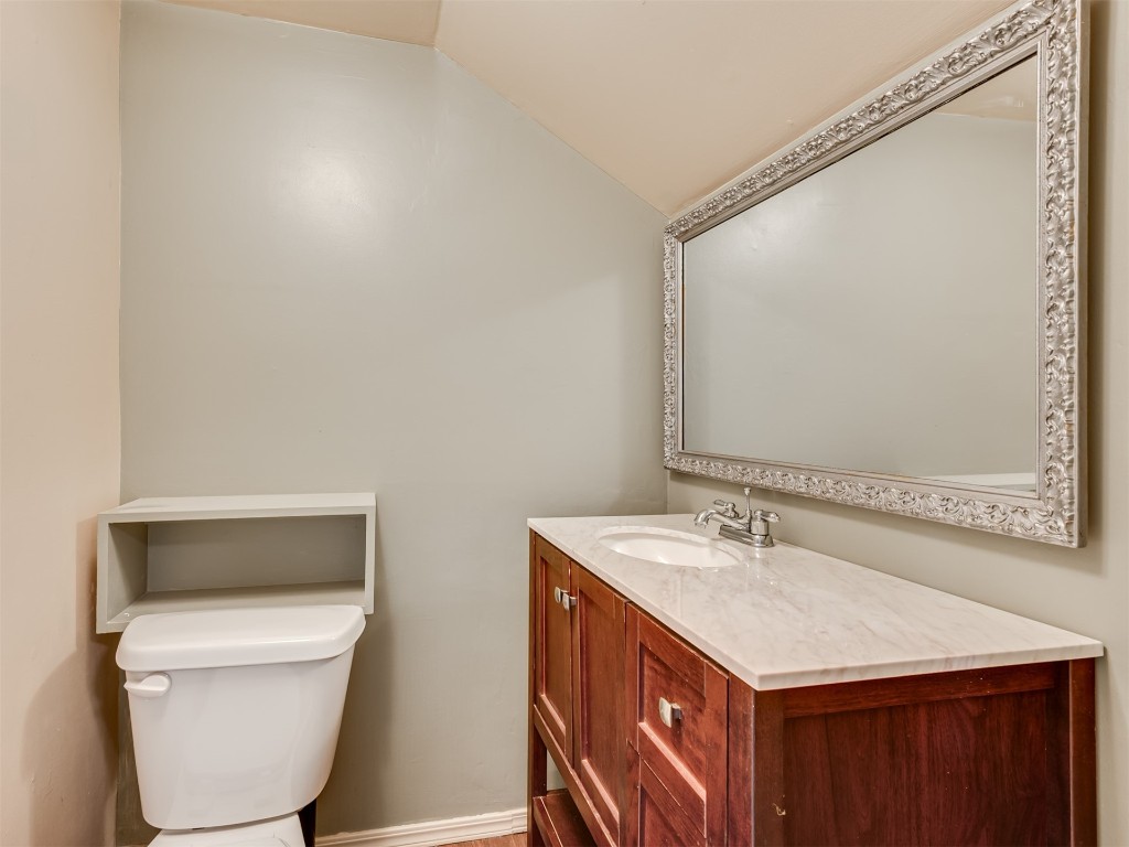 9625 Ritter Road, Oklahoma City, OK 73162 bathroom featuring vaulted ceiling, oversized vanity, and toilet
