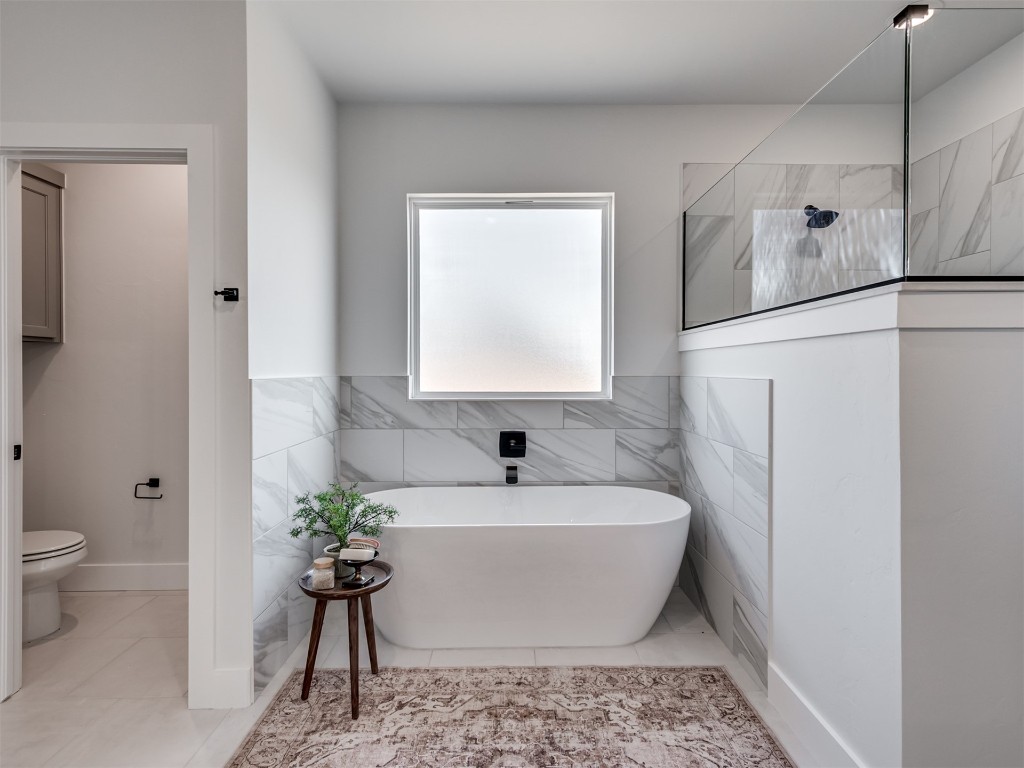 446 Venetian Avenue, Piedmont, OK 73078 bathroom with tile walls, a tub, tile floors, and toilet