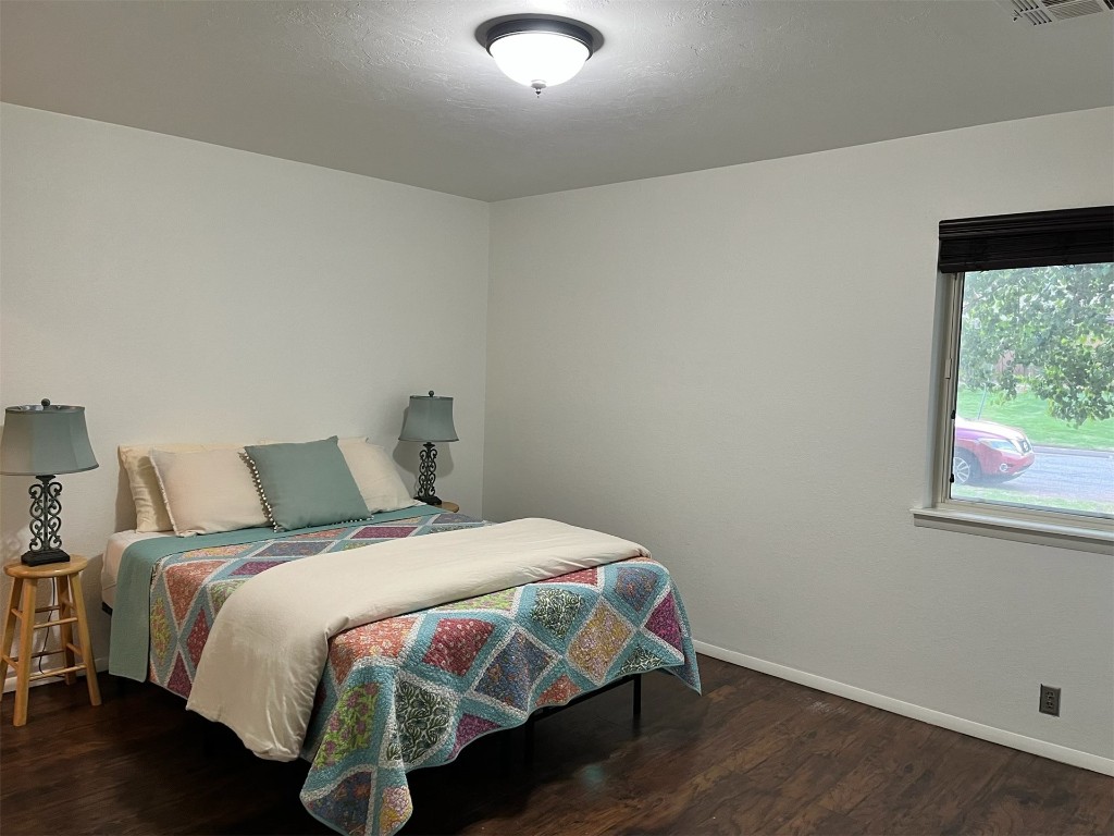 9601 Hefner Village Boulevard, Oklahoma City, OK 73162 bedroom with dark wood-type flooring