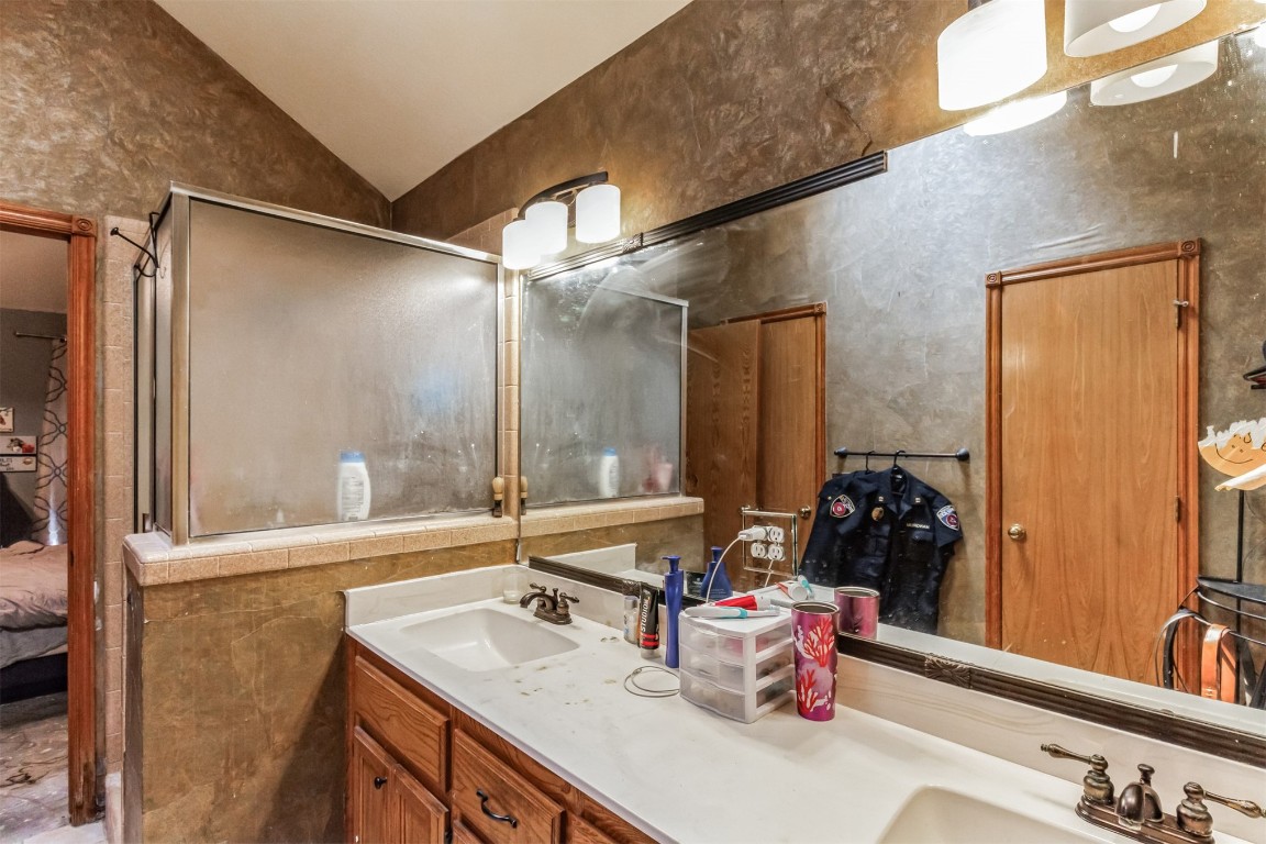 428 E Magnolia Terrace, Mustang, OK 73064 bathroom with vaulted ceiling and large vanity