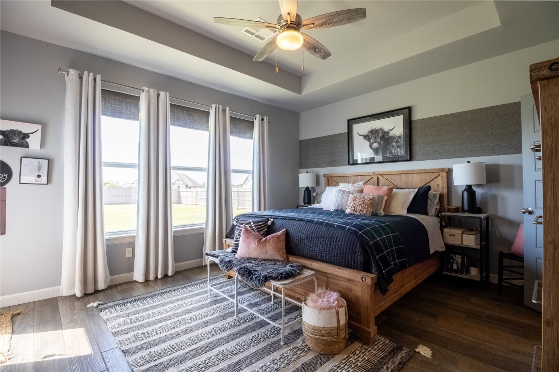7208 SW 121st Street, Oklahoma City, OK 73173 bedroom featuring hardwood / wood-style floors, ceiling fan, and a raised ceiling