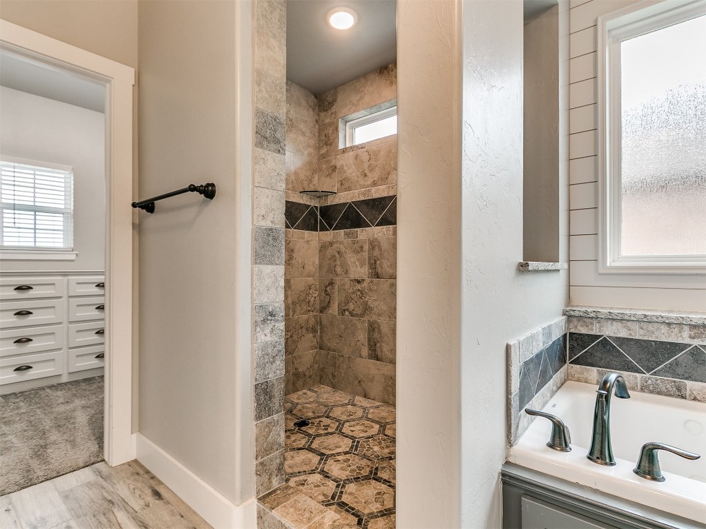 26812 Bridlewood Road, Blanchard, OK 73010 bathroom featuring plus walk in shower, a wealth of natural light, and hardwood / wood-style flooring
